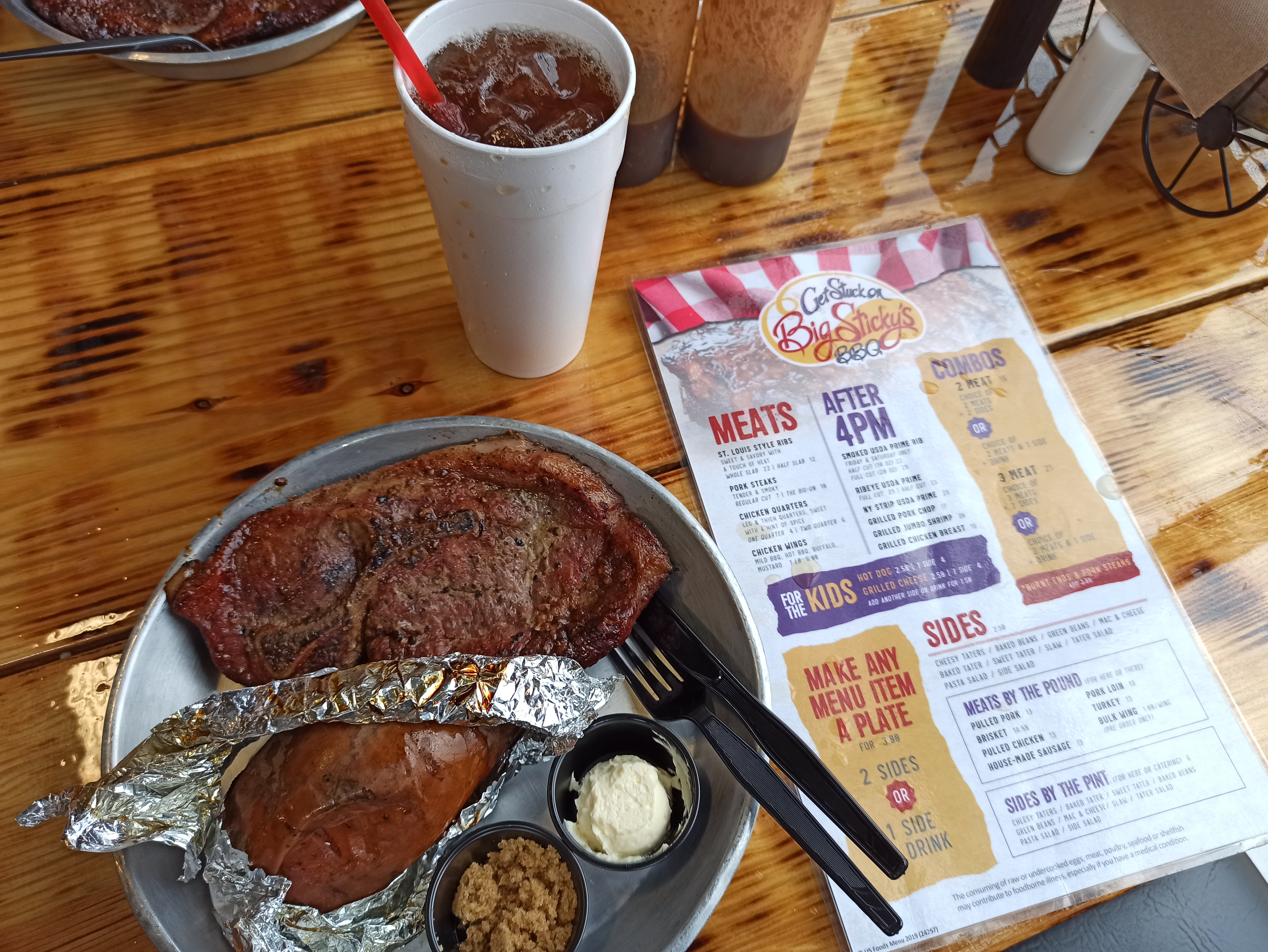 a plate of meat and a drink on a table