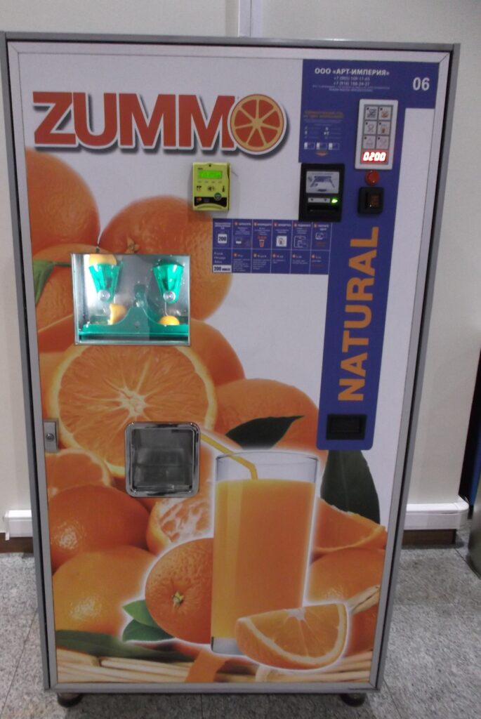 a vending machine with oranges on the side