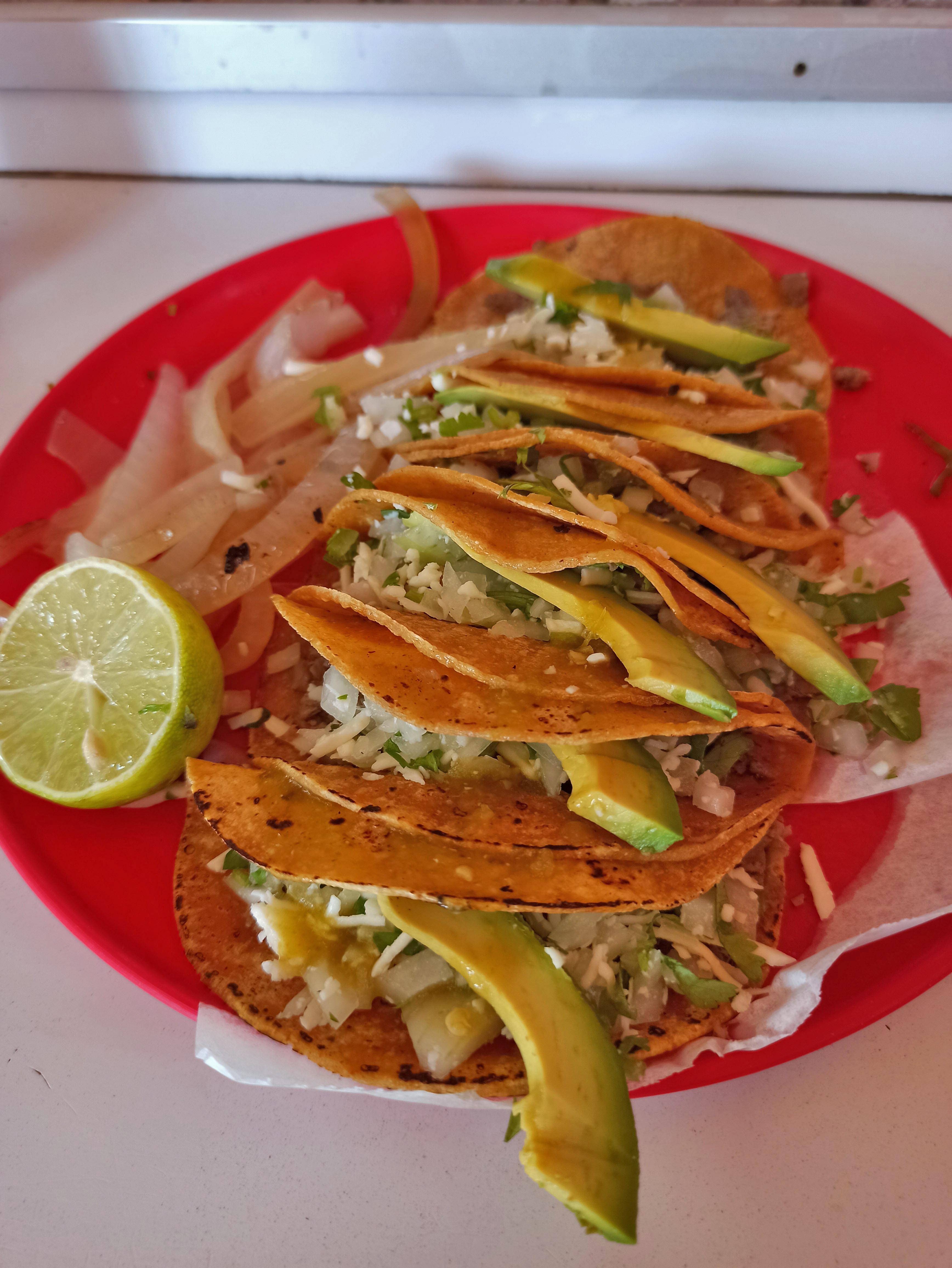 a plate of tacos with avocado and onions