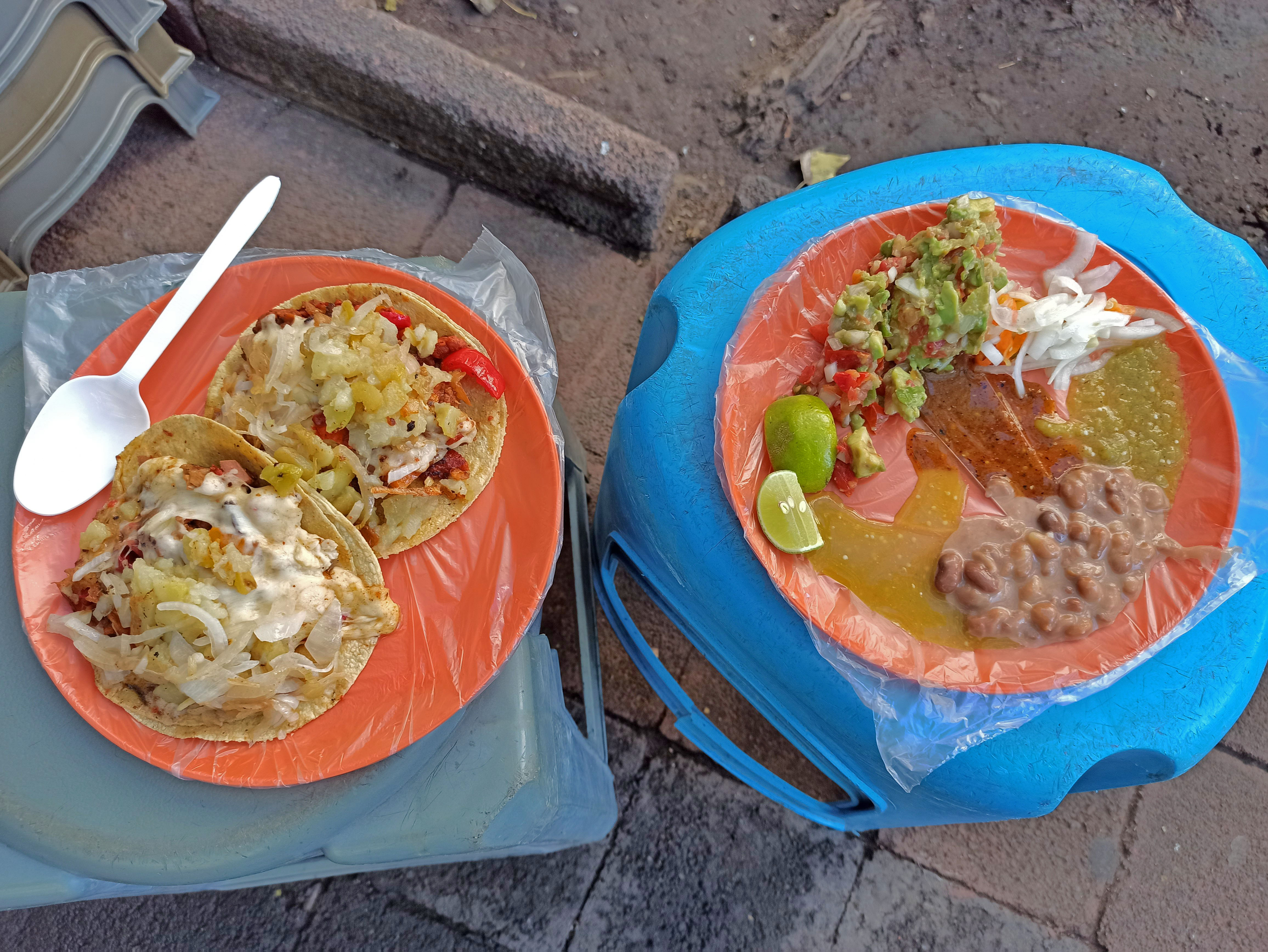 two plates of tacos on a concrete surface