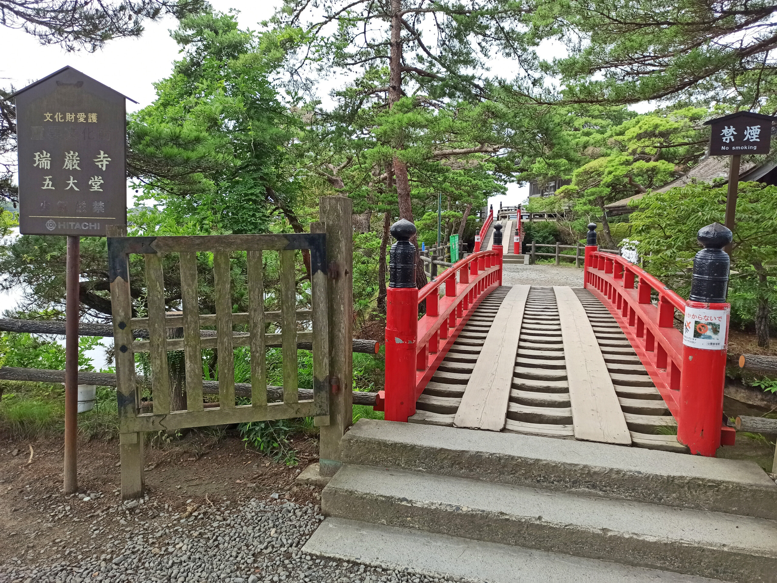 a bridge with red railings and a sign
