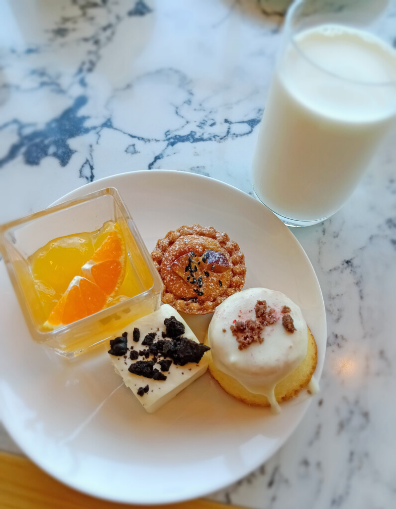 a plate of desserts and a glass of milk