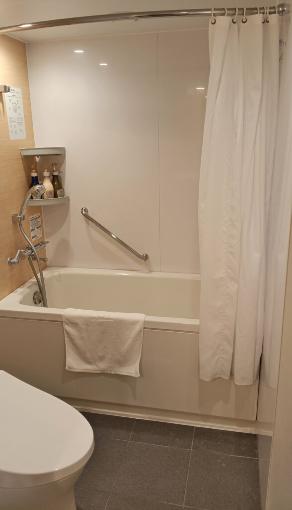 a bathtub with a shower curtain and a towel from it