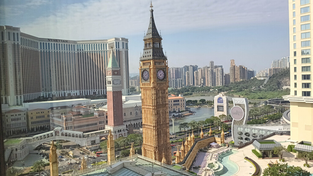 a clock tower with a large tower and a river in the background