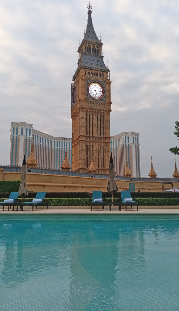 a clock tower with a pool in front of it