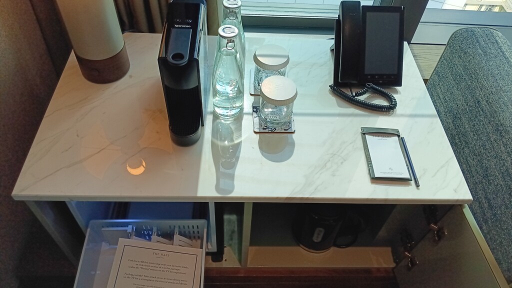 a desk with a phone and bottles on it