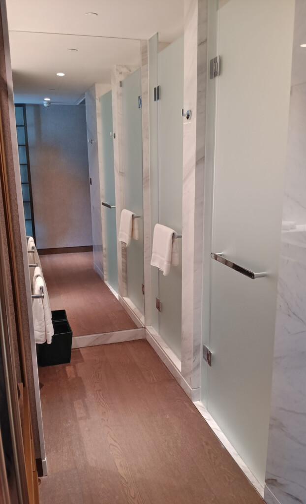 a bathroom with glass doors and white towels