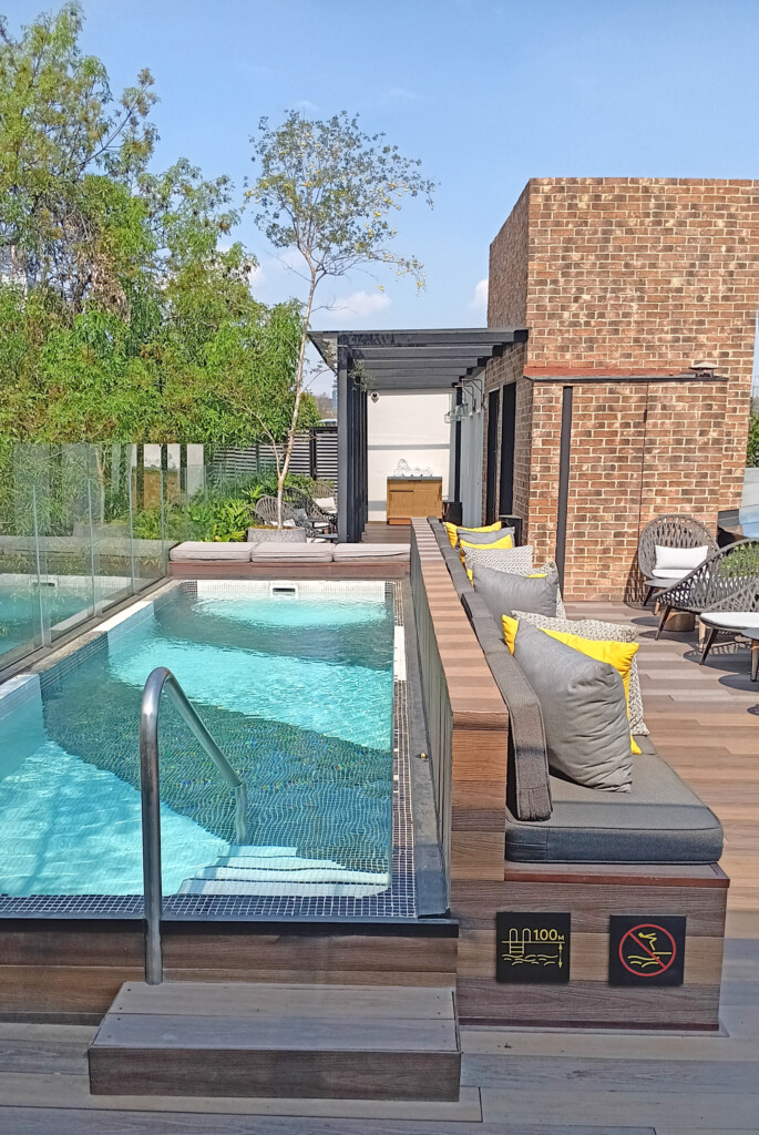 a pool with a bench and a brick building