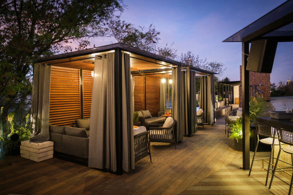 a patio with a covered area with chairs and a table