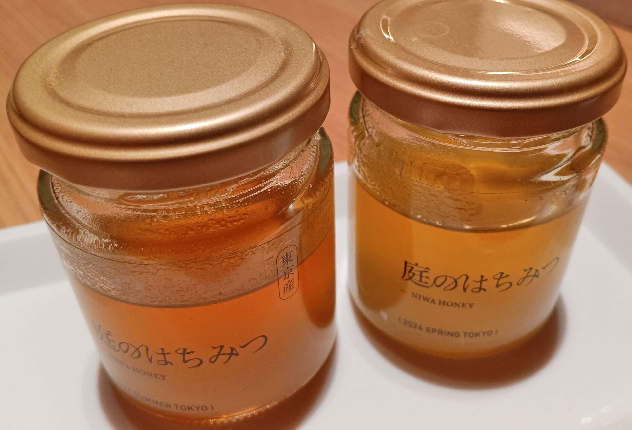 two jars of honey with a gold lid