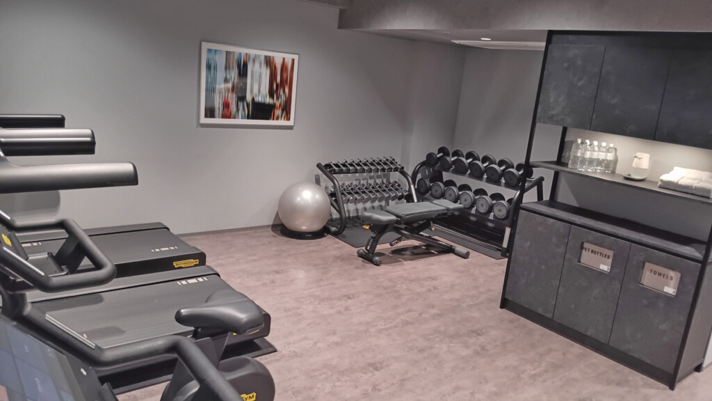 a room with exercise equipment and a large mirror