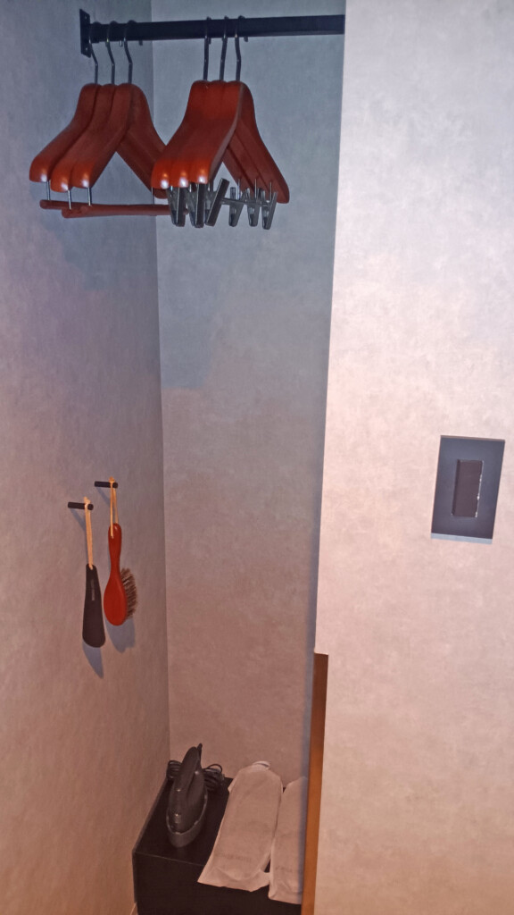 a rack with a broom and brushes on the wall
