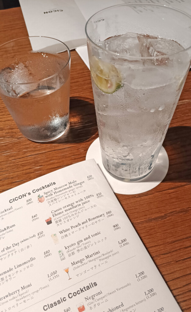 a glass of water and a menu on a table
