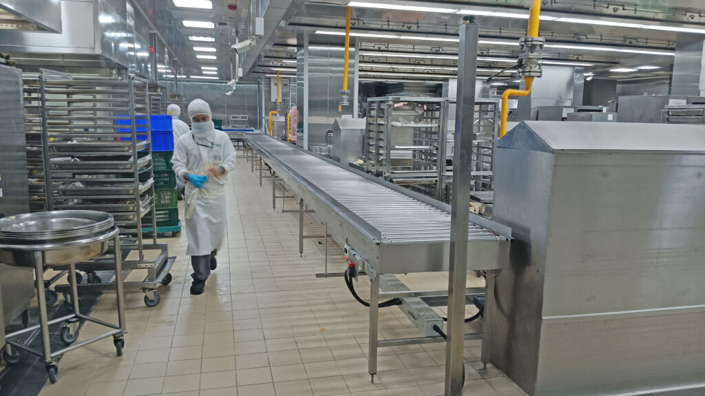 a person in a white robe walking through a factory