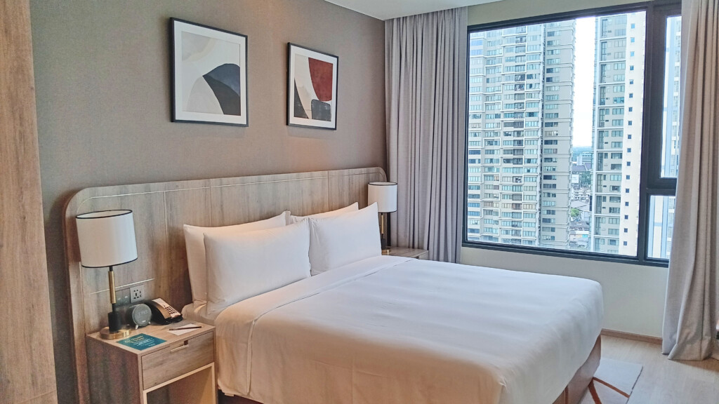 a bed with a lamp and a window