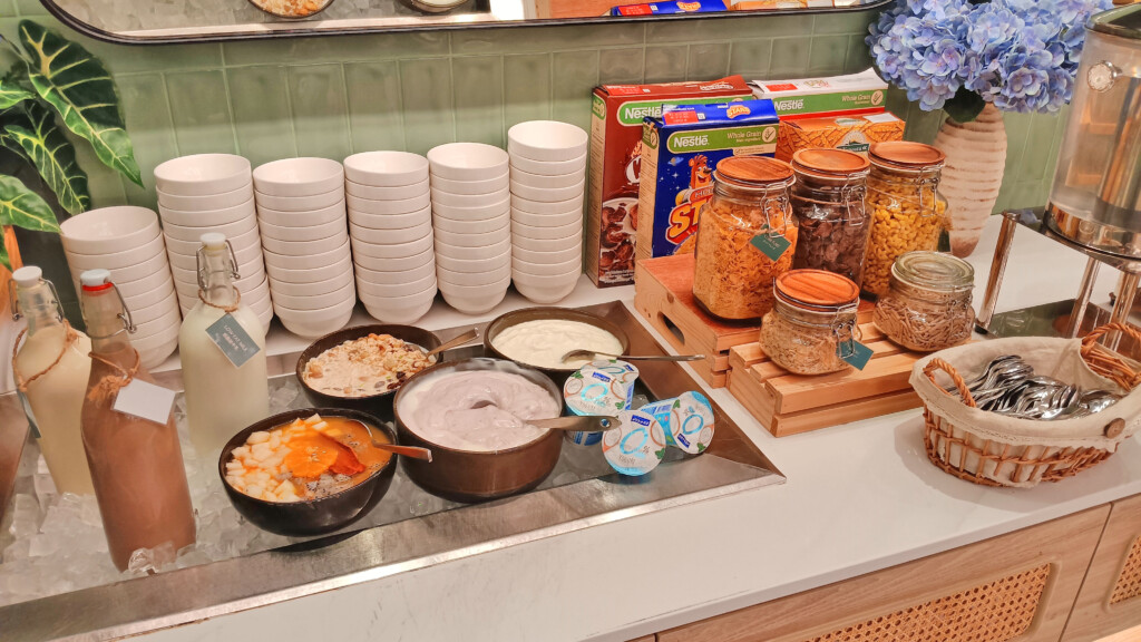 a counter with bowls of food and cereals