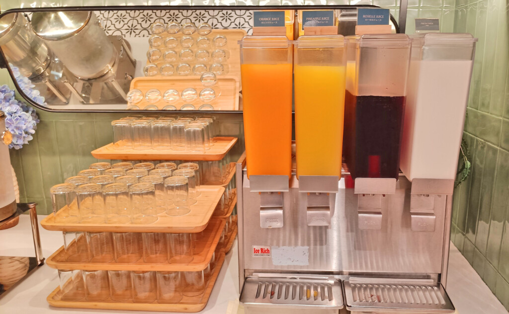 a group of glasses and juice dispensers