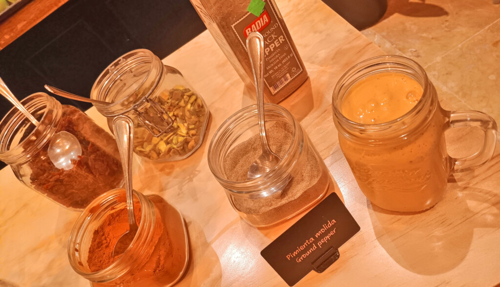 a group of jars with spices and a spoon