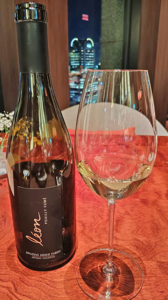 a bottle of wine next to a glass