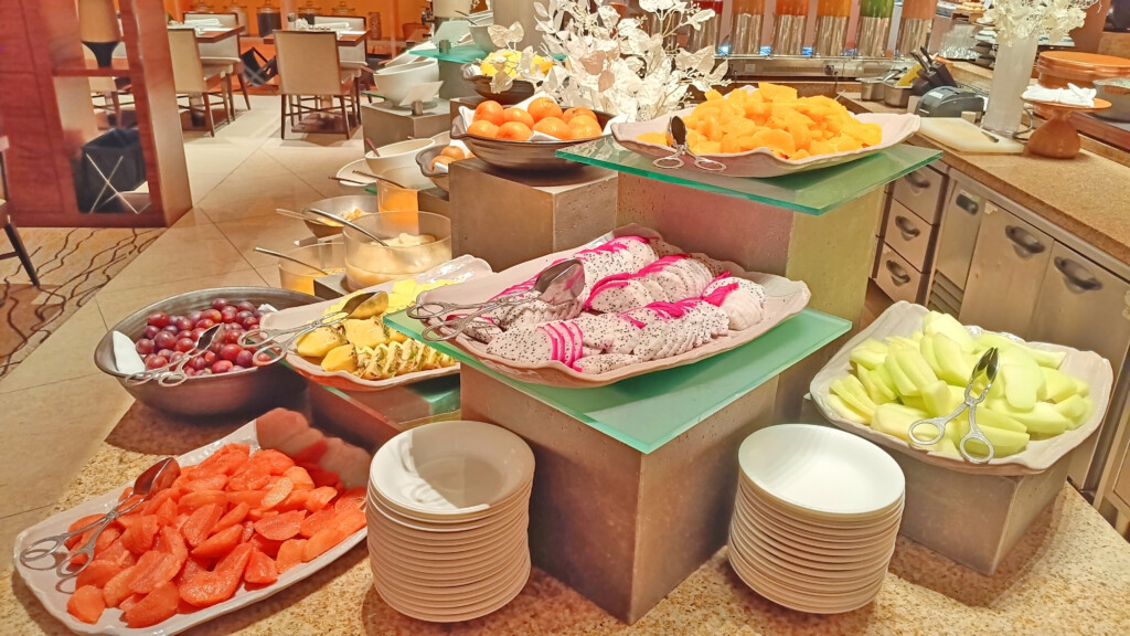 a buffet table with plates of fruit and bowls of food