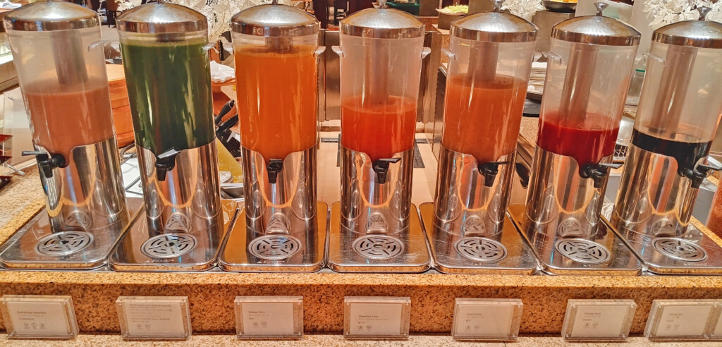 a group of juice dispensers on a counter
