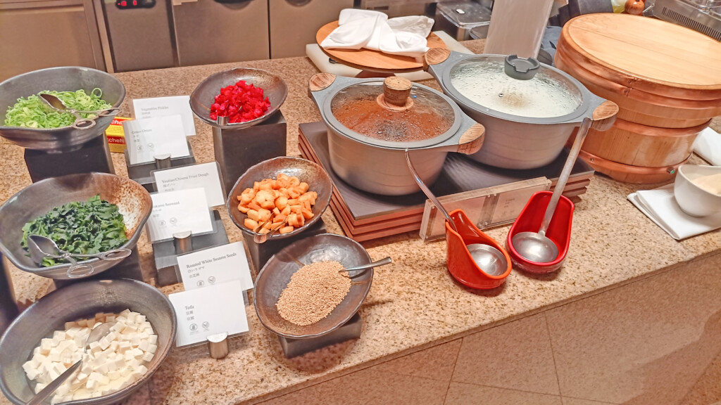 a table with bowls of food and ladles