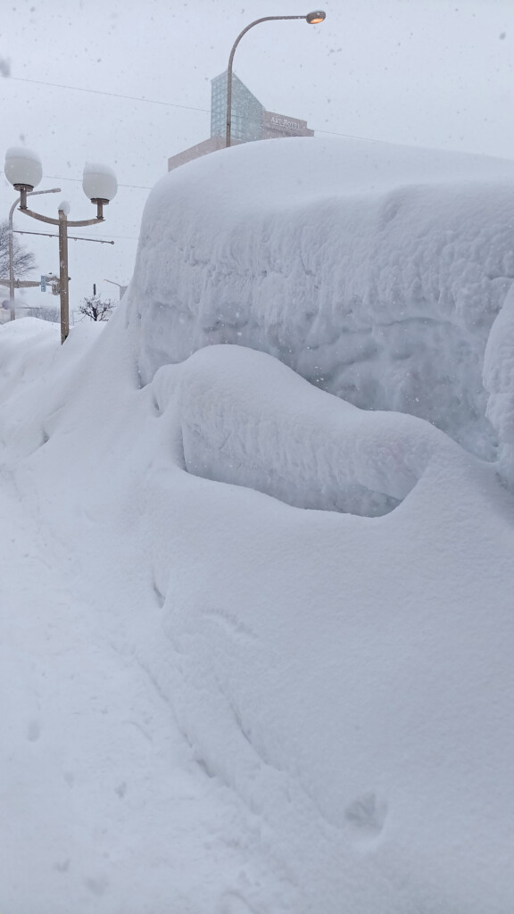a snow covered car on a street