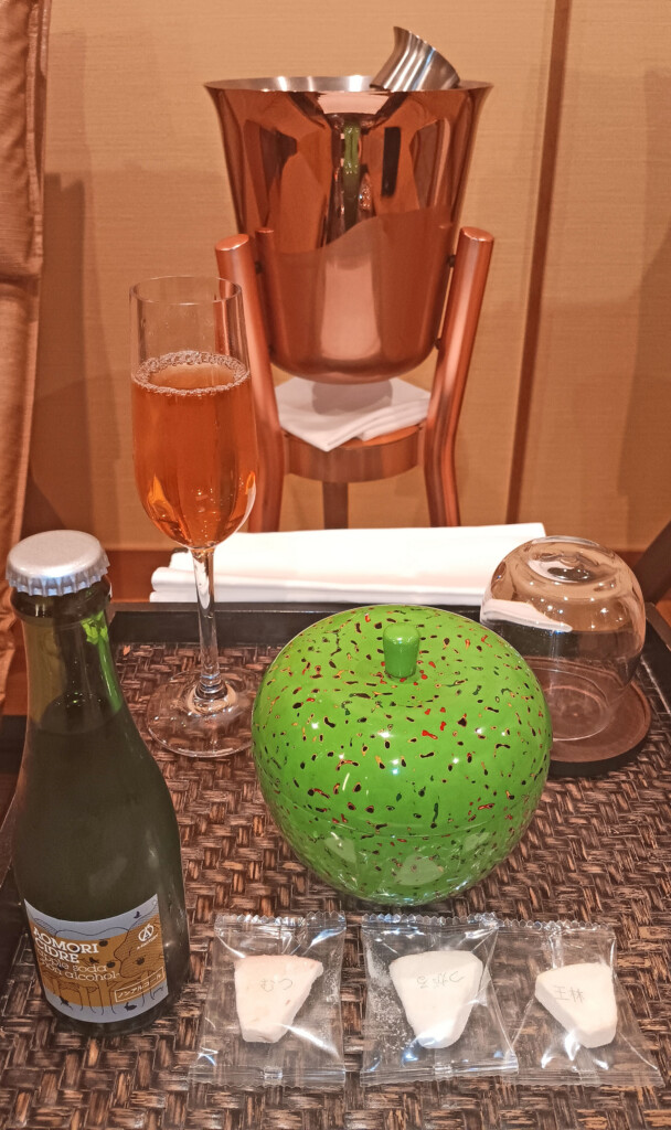a table with a glass of wine and a green apple