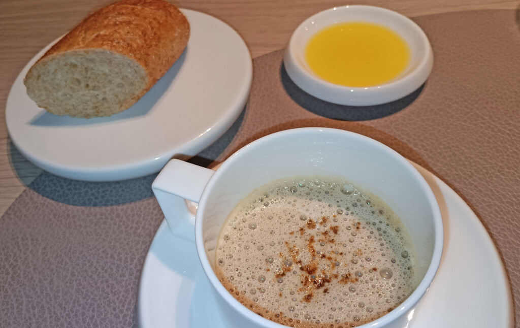 a cup of coffee and a loaf of bread on plates