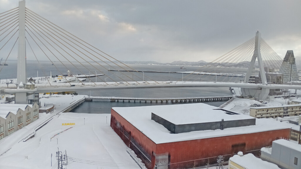 a bridge with snow and a building