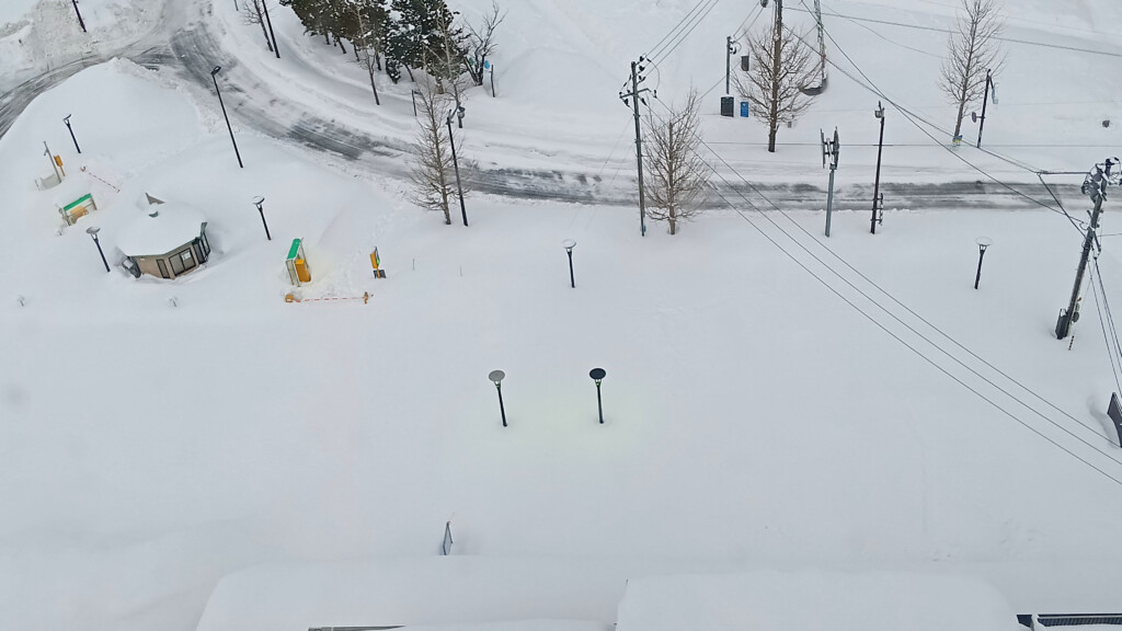 a snow covered ground with power lines and street