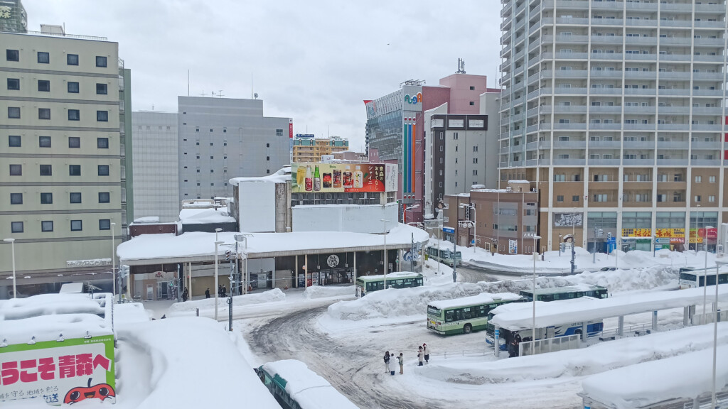 a city with snow covered buildings and buses