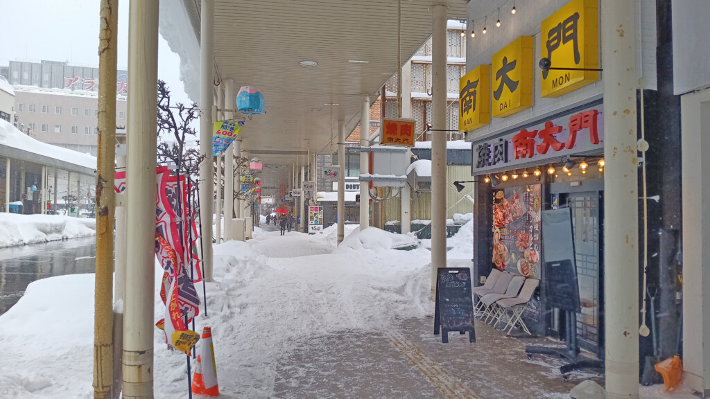 a snow covered walkway with signs and signs on it