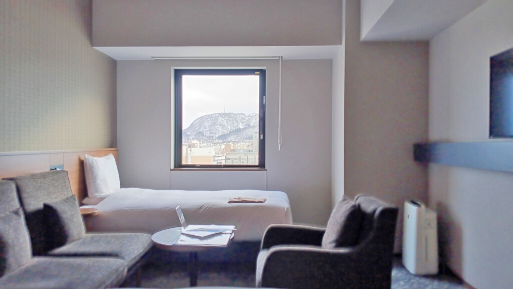 a room with a bed and chairs