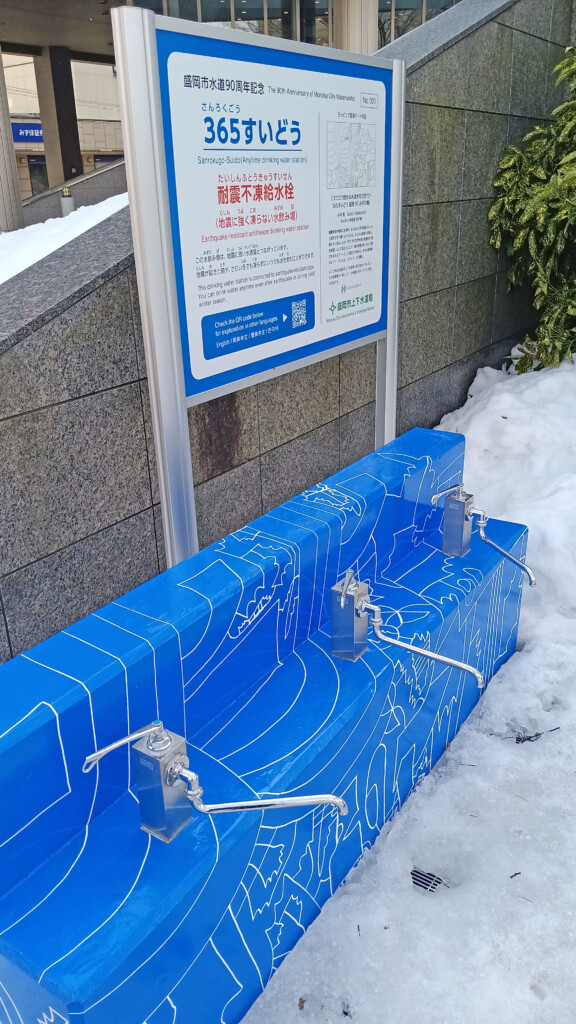 a blue bench with white lines on it next to a sign