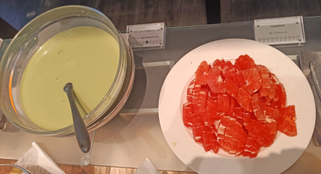 a plate of orange slices on a glass tray next to a bowl of liquid