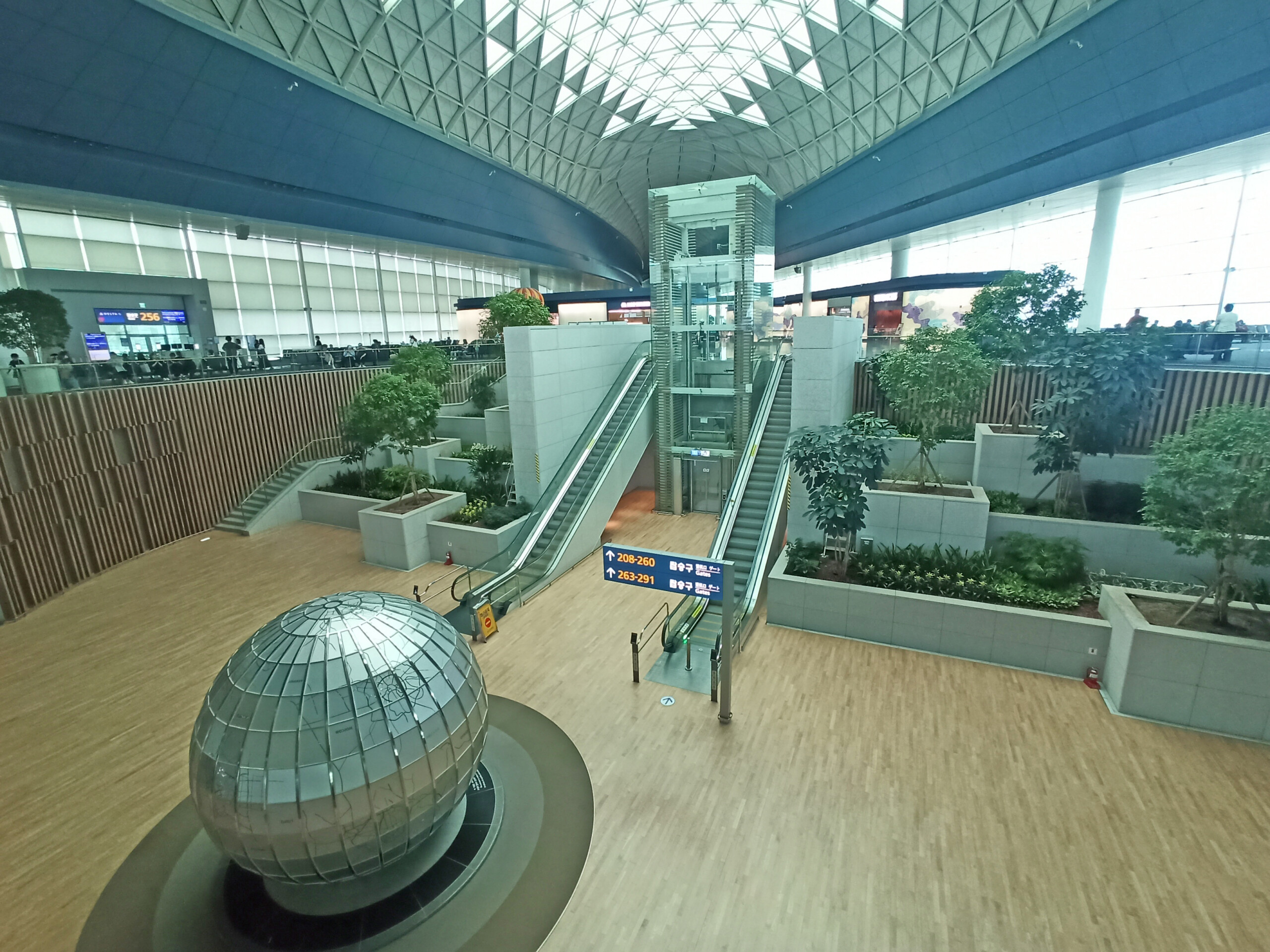 The foreground art installation near gate 264 has some city maps
